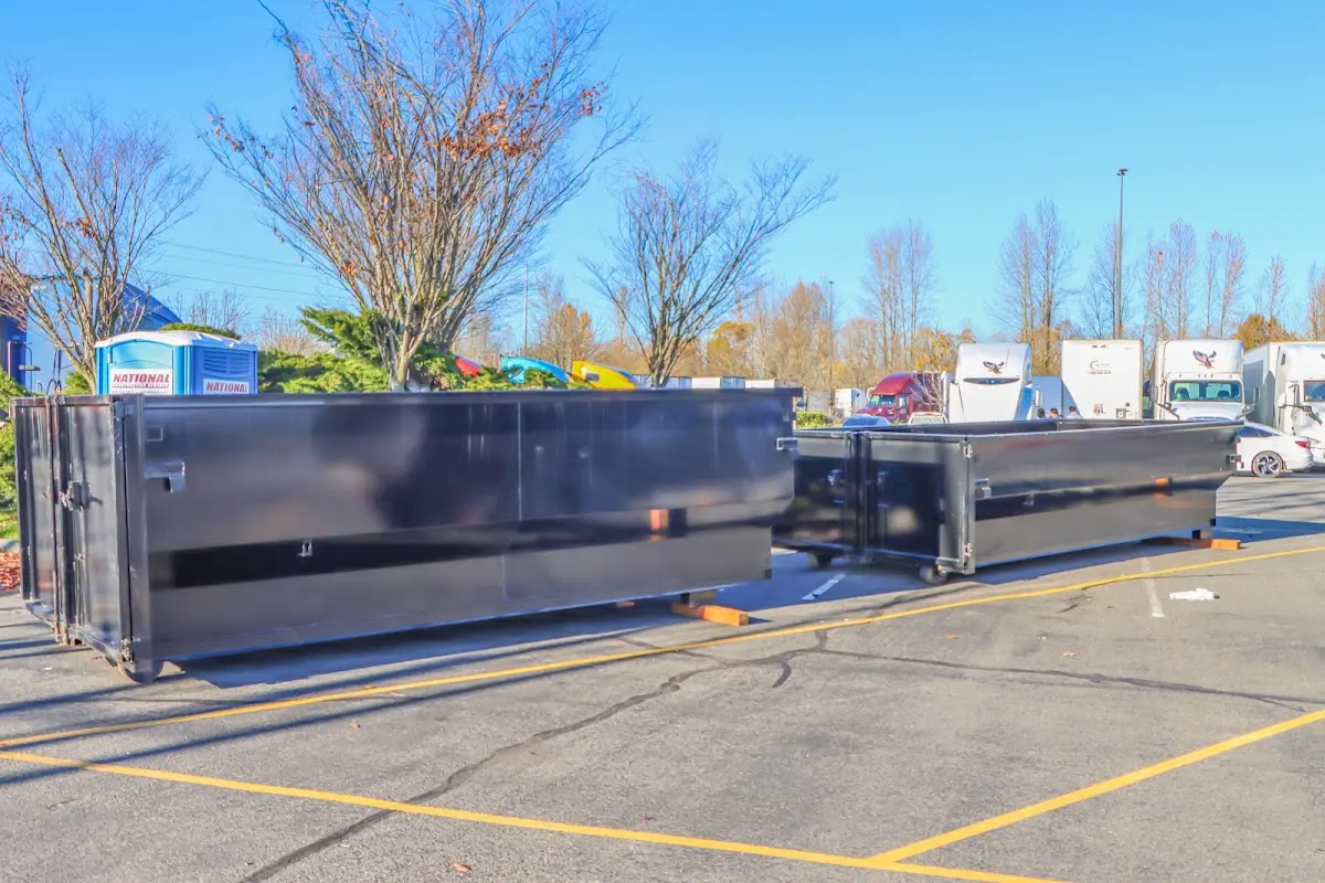 Professional dumpster rental service with roll-off container on residential driveway in East Milton